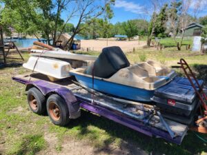 Multiple paddle boats and other items loaded on a trailer for junk removal by TrashnSell in Grand Island, NE