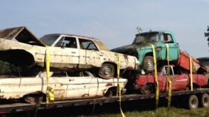 Multiple old scrap cars loaded onto a trailer for removal by Cash For Scrap Vehicles / Junk Removal in Minneapolis, MN.