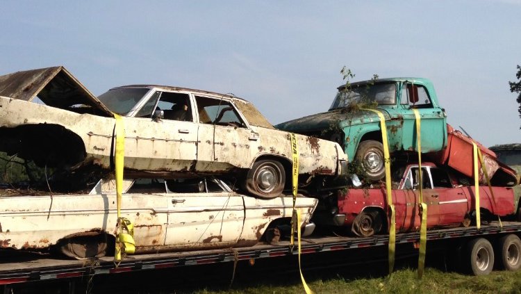Multiple old scrap cars loaded onto a trailer for removal by Cash For Scrap Vehicles / Junk Removal in Minneapolis, MN.