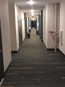 A long residential hallway showing multiple trash bins ready for valet trash service by Elite Valet Trash in Apex, NC.