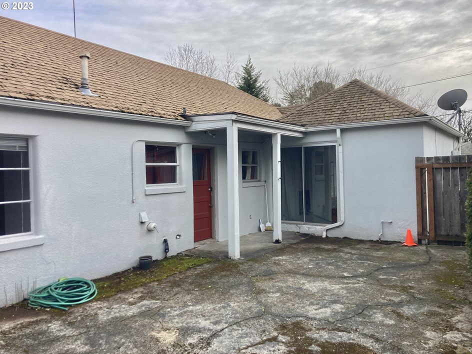 A neglected back patio area with cracked concrete and worn house exterior, ready for handyman services from Gordon Homes LLC in Portland, OR.