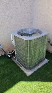 A new outdoor AC unit professionally installed on artificial turf by Medina's Handyman LLC in Las Vegas, NV