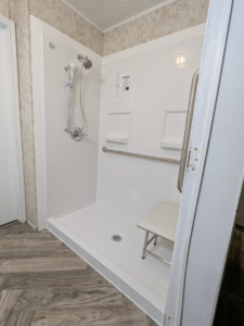 A newly installed accessible shower with a grab bar and seat by Louisiana Special Needs Consultants, LLC in Opelousas, LA.