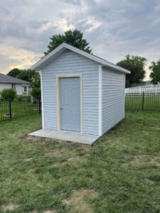 A newly constructed backyard storage shed with light blue siding by CJP Construction handyman services in Pierce, NE.