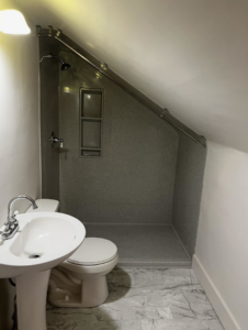 A newly installed bathroom with a modern shower, toilet, and sink by Bill's Handyman Services in Anchorage, AK.