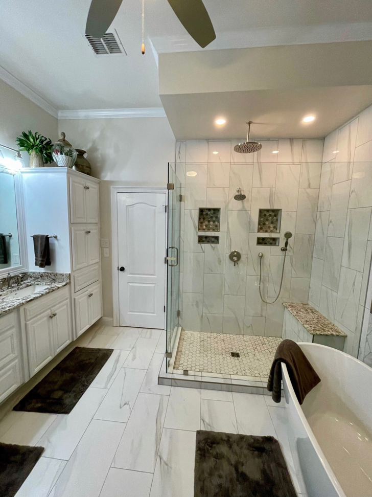 A newly remodeled modern bathroom with a walk-in shower and white vanity by Shreveport Contractors in Shreveport, LA.