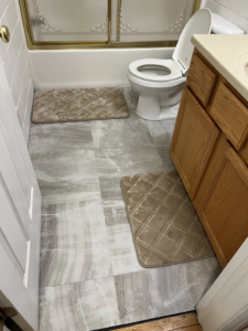Newly installed light-colored tile flooring in a bathroom by GOAT Tv Mounting & Home Improvement L.L.C in Toledo, OH.