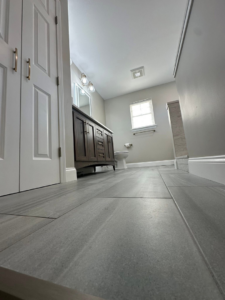 New large format tile flooring in a renovated bathroom by Quality Work Home Services in Syracuse, NY.