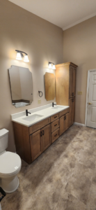 A newly installed bathroom vanity with double sinks, mirrors, and toilet by Willhite Construction in O'Fallon, MO.