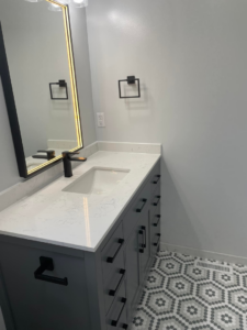 A new bathroom vanity with a white countertop and black fixtures installed by Capital T's Home Specialty LLC in Topeka, KS.