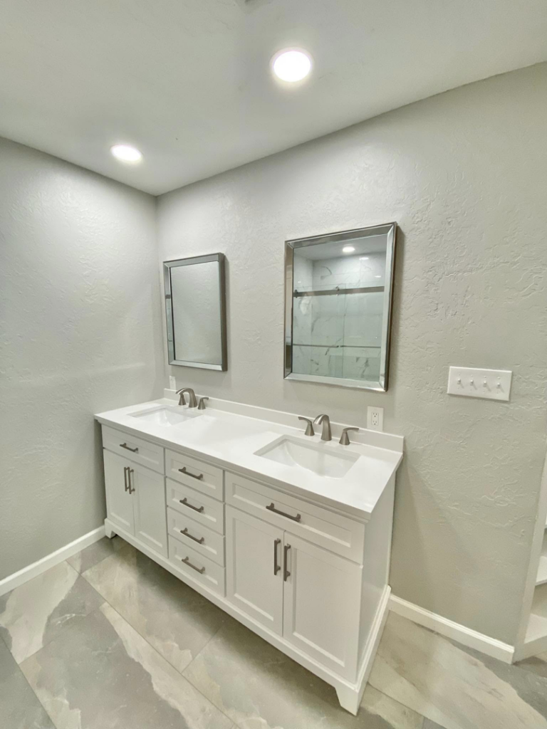 A newly installed bathroom vanity with double sinks and mirrors by Cutting Edge Carpentry & Construction in Lawton, OK.