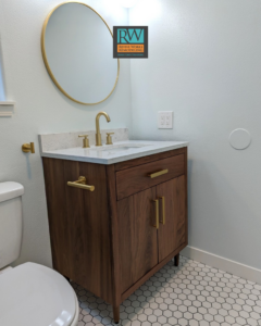 A newly installed bathroom vanity with a modern sink and gold fixtures by Revive Works Remodeling in Portland, OR.