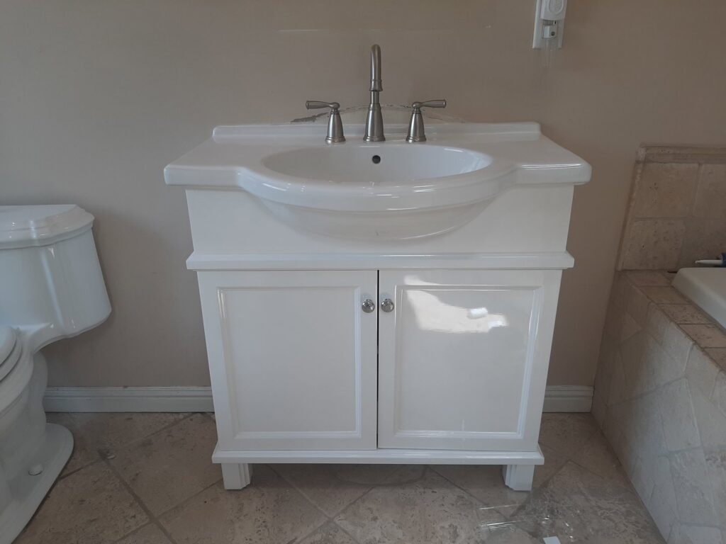 A new white bathroom vanity, sink, and toilet installed by Victor White Handyman in Long Beach, CA
