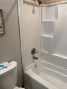 New white bathtub and shower surround installation in a bathroom by Vargas Paint and Texture in San Antonio, TX.