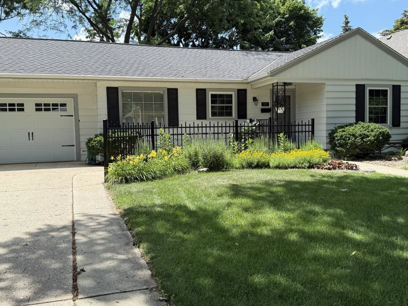 A newly installed black metal fence in the front yard of a home by A to Z Quality Fencing and Structures-Appleton, WI.