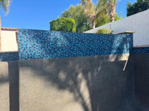 Newly installed blue mosaic tiles on a swimming pool wall by Mr. Pools LLC in Gilbert, AZ.
