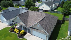 An aerial view of a suburban home featuring a new brown shingle roof installed by Coastal Roofing Solutions LLC in Charleston, SC.