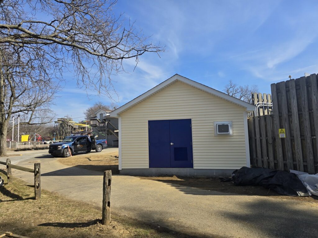 A newly constructed building with light yellow siding and blue doors, completed by Ben Nye The Fix-It Guy in Erie, PA.