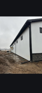 A newly constructed building with white siding and black trim, showcasing general contractor work by J and R Contracting in Buffalo, NY.