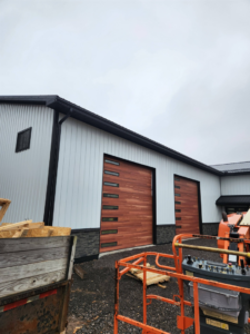 A new building featuring modern wooden garage doors and exterior siding by J and R Contracting in Buffalo, NY.