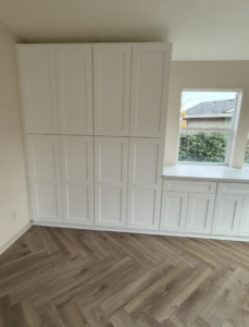 Newly installed white cabinets and herringbone flooring by Reborn Construction LLC in Wilsonville, OR.