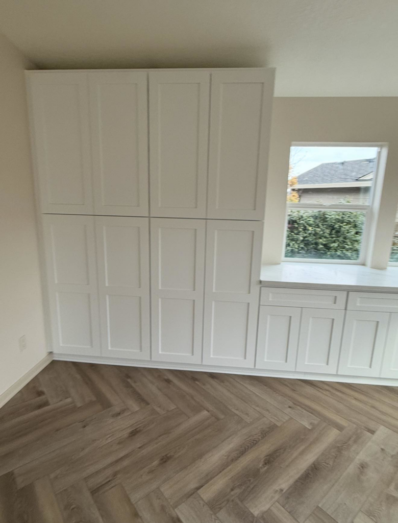 Newly installed white cabinets and herringbone flooring by Reborn Construction LLC in Wilsonville, OR.