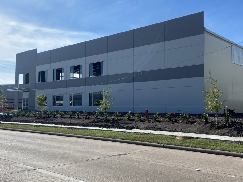 Exterior view of a newly constructed commercial building with landscaping, a general contractor project by Spectrum Paint and Commercial Services, Inc. in Houston, TX.