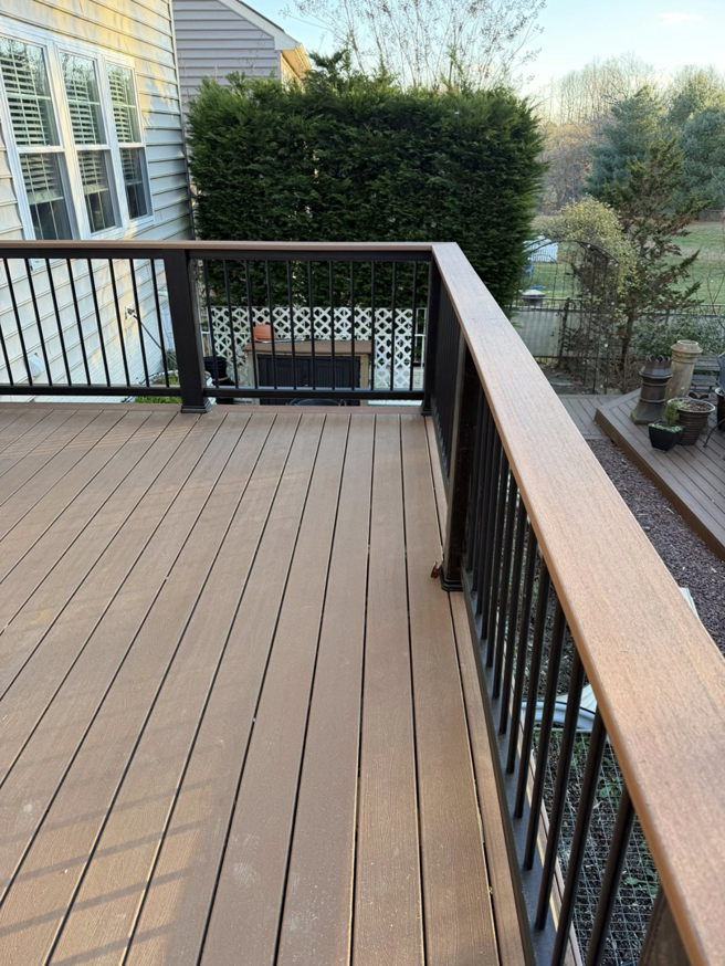A newly installed composite deck with sleek black railings by Harris Home Creations in Philadelphia, PA.