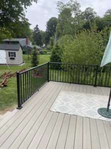 A new composite deck with modern black railings and outdoor furniture by Horstman Construction in Erie, PA.