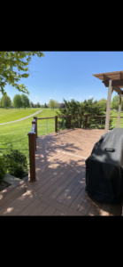A newly installed composite deck with modern cable railings overlooking a golf course by Nader Builders in Ann Arbor, MI.