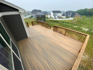 A newly constructed composite deck with wooden railings by Strom Contracting LLC in Crystal Lake, IL.