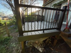 A view of a newly constructed composite deck with black railings, showcasing work by The Golden Touch handyman services in Huntington, WV.
