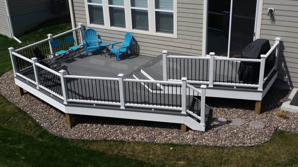 Newly built composite deck with white railings and black balusters, featuring outdoor furniture by Tschida Construction in Cologne, MN.
