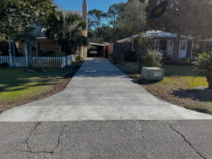 A newly installed and finished concrete driveway by Unified Roofing and Exteriors in Gulf Shores, AL.