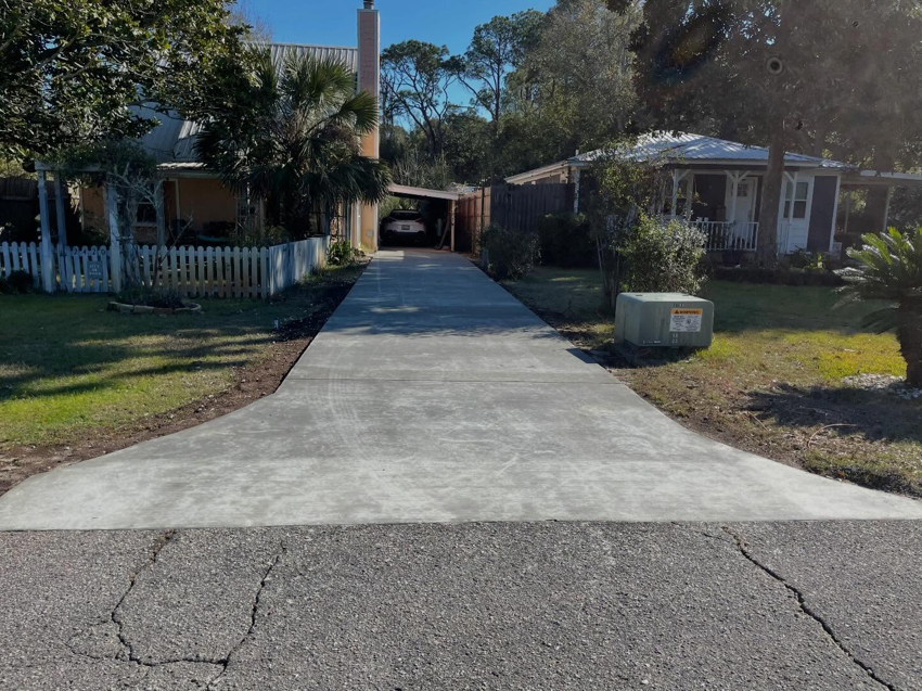 A newly installed and finished concrete driveway by Unified Roofing and Exteriors in Gulf Shores, AL.