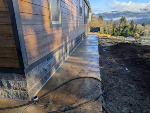 A newly installed concrete pathway alongside a house by United Property Improvement, a handyman service in Eugene, OR.