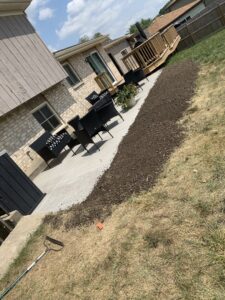 A new concrete patio with a decorative gravel border next to a residential house, completed by Moons Concrete & Construction LLC in Chicago, IL.