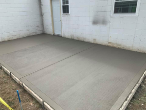 A newly installed concrete patio next to a building, expertly done by Complete Concrete of Indy, Inc. in Fishers, IN.