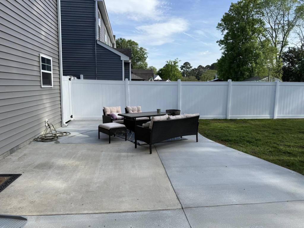 A newly installed concrete patio with outdoor furniture by McGhee's Concrete in Chesapeake, VA.