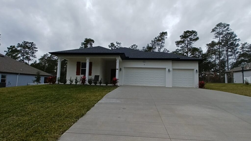 A new construction home exterior with a two-car garage by Coastal Pointe Homes, a trusted general contractor in Tampa, FL.