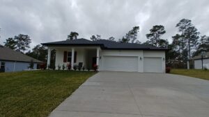 A new construction home exterior with a two-car garage by Coastal Pointe Homes, a trusted general contractor in Tampa, FL.