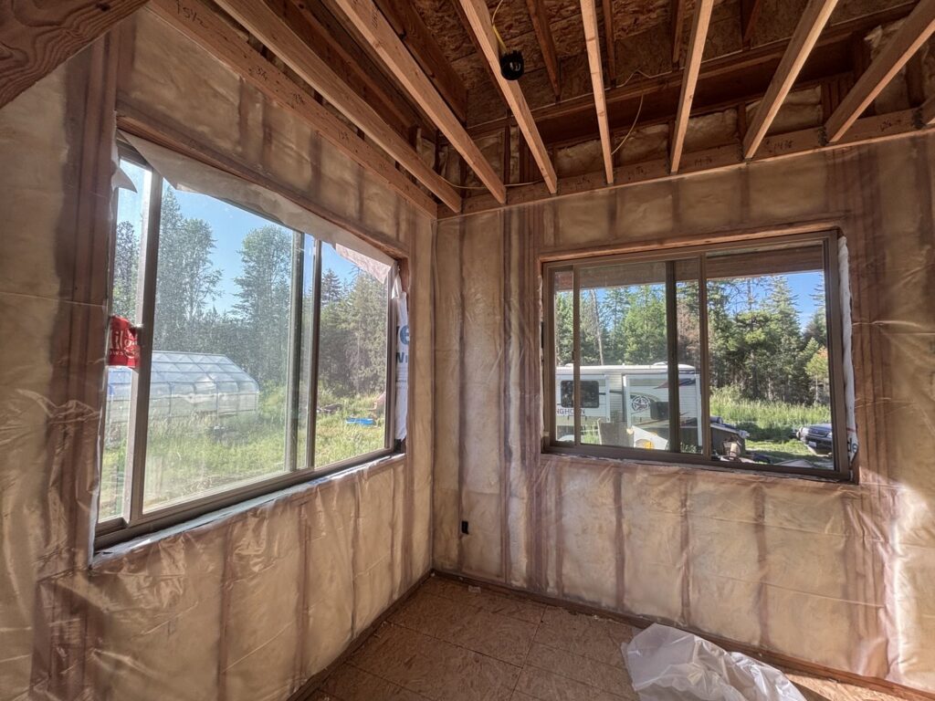 A room under construction with insulation wrap installed on the walls by Pacific Insulation & Mold Remediation in Spokane, WA.