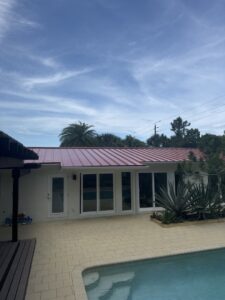 Workers installing a new metal roof on a house under construction, a general contractor project by Hastings Roofing Service Inc. in Orlando, FL.