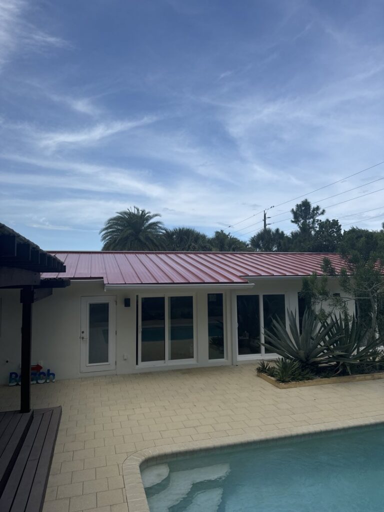 Workers installing a new metal roof on a house under construction, a general contractor project by Hastings Roofing Service Inc. in Orlando, FL.