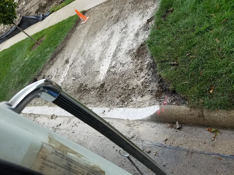 A newly installed curb line with disturbed earth, showing general contractor site work by National Kurb Kut in Naperville, IL.