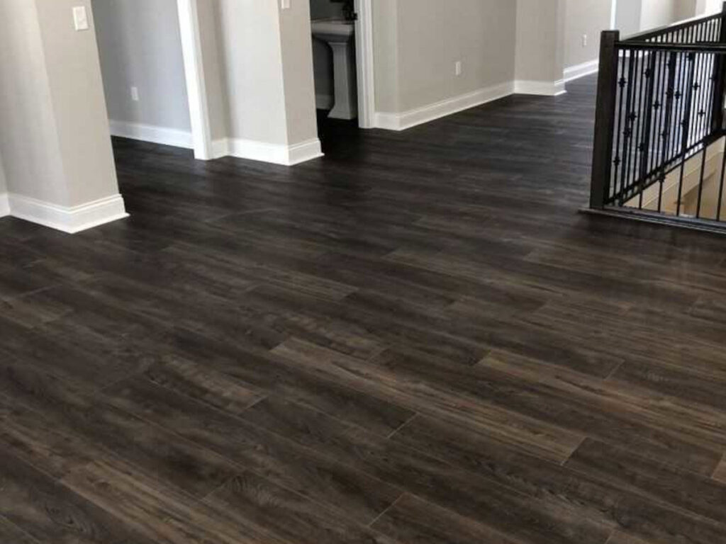 Newly installed dark wood-look flooring in a home, showcasing a completed project by Huntington Home Repair in Huntington, WV.