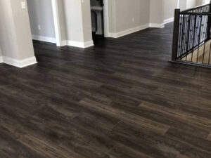 Newly installed dark wood-look flooring in a home, showcasing a completed project by Huntington Home Repair in Huntington, WV.