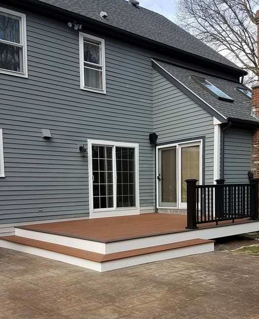 A newly installed deck and siding on the exterior of a home by Caldwell Construction in Richardson, TX