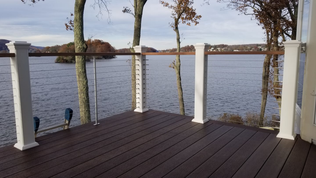 A newly constructed deck with modern cable railings offering a scenic lake view by David Hayden Construction LLC in Danbury, CT.
