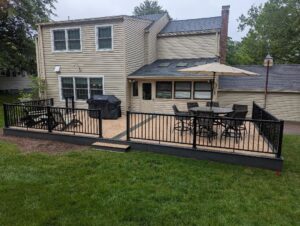 A newly constructed outdoor deck with black railings by Bartlett Brainard Products Co. in West Hartford, CT.